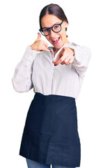 Beautiful brunette young woman wearing professional waitress apron smiling doing talking on the...