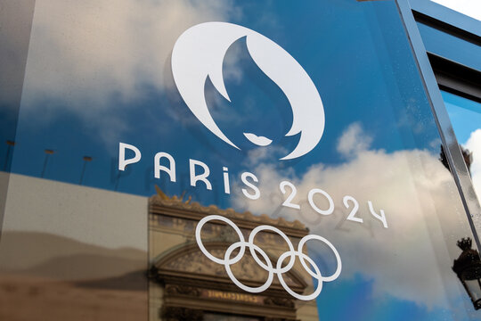 Paris, France - 6 décembre 2023: Gros plan du logo de Paris 2024, symbole des Jeux olympiques d'été de Paris, sur une vitre avec les anneaux olympiques