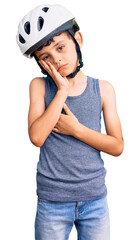 Little cute boy kid wearing bike helmet thinking looking tired and bored with depression problems...