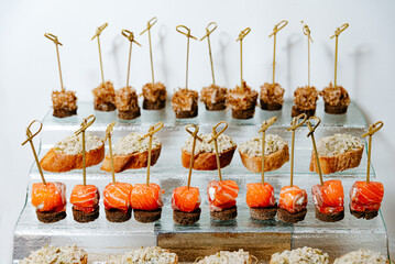 Smoked Salmon and Tuna Canapes on Glass tray. An array of sophisticated smoked salmon canapés with...