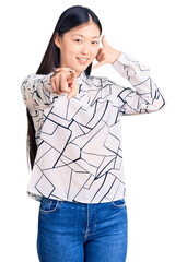 Young beautiful chinese woman wearing casual shirt smiling doing talking on the telephone gesture...