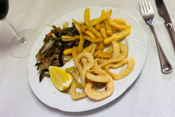 Delicious andalusian fried squid served sliced into rings on platter in restaurant
