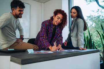 A female data analyst is working on graphs at office with colleagues.