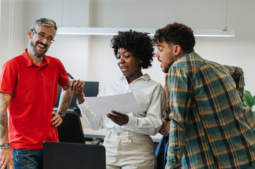Multicultural businesswoman is explaining documentation to her team at office.