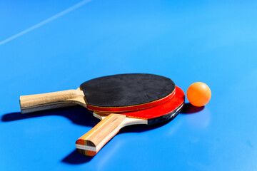 Rackets and ball on the blue tennis table.