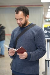 Man checking his air flight ticked and his passport at terminal on airport 