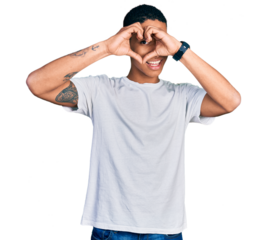 Young hispanic man wearing casual white t shirt doing heart shape with hand and fingers smiling looking through sign