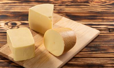 Cheeses, beautiful pieces of cheese placed on rustic wood, selective focus.
