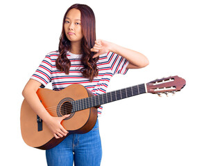 Fototapeta premium Young beautiful chinese girl playing classical guitar with angry face, negative sign showing dislike with thumbs down, rejection concept