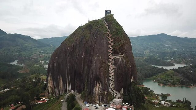 Aerial drone footage of El Penon de Guatape near Medellin in Antioquia, Colombia. Large and unique alone rock with stairs to the top, touristic place. Big stone in Colombia. High quality 4k footage.