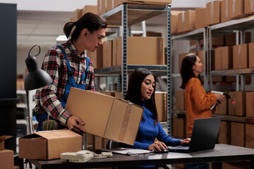 Warehouse asian employees managing ecommerce order fulfillment in storage room. Storehouse carrier...