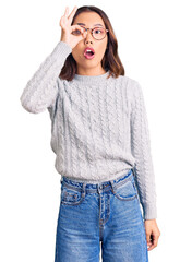 Fototapeta premium Young beautiful chinese girl wearing casual clothes doing ok gesture shocked with surprised face, eye looking through fingers. unbelieving expression.