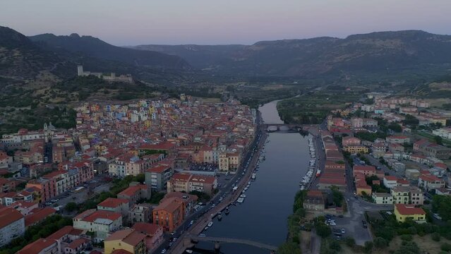 Aerial drone view of Bosa historic city colorful houses and castle with Temo river and historic bridge at sunset in Sardinia, Italy