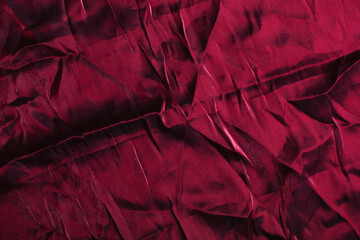 Texture, background, pattern. crumpled silk or satin cloth dark red color. Smooth elegant magenta...
