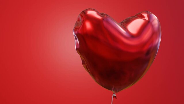 red foil balloon in the shape of a heart close-up on a red background