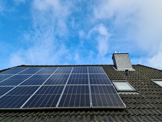 Fototapeta premium Solar panels producing clean energy on a roof of a residential house