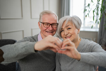 Love heart shape peace. Senior older couple making heart shape with their hands. Adult mature old husband wife showing heart sign. Happy pensioner family. I love you happy valentines day