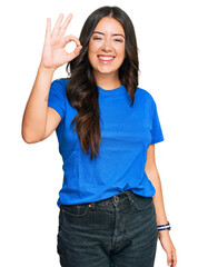 Fototapeta premium Beautiful brunette young woman wearing casual clothes smiling positive doing ok sign with hand and fingers. successful expression.
