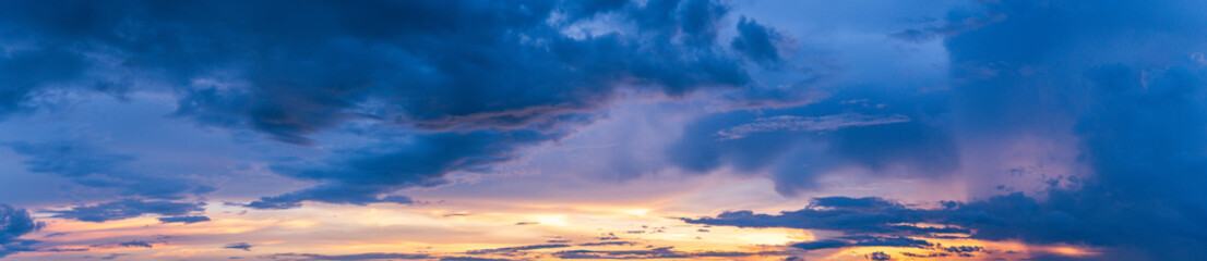 Enjoy the wide and colorful panorama of a sunset, where fluffy clouds adorn the horizon in hues of...