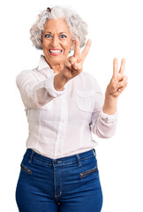 Senior grey-haired woman wearing casual clothes smiling looking to the camera showing fingers doing victory sign. number two.