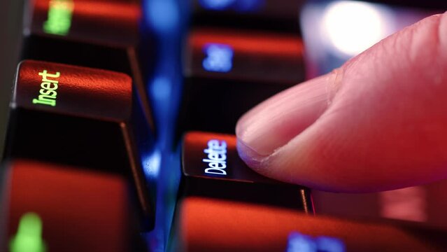 Person is in doubt whether to press the Delete key or not. The finger hovers over the Delete key for a few seconds before deciding to press it. Yes or no concept. A heavy dicision do it or not.