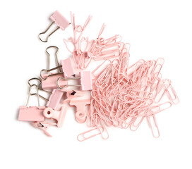 Set of pink paper clips, binders and pins on white background