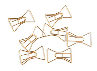 Rose gold paper clips in shape of bows on white background