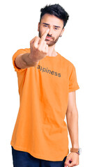 Young hispanic man wearing t shirt with happiness word message showing middle finger, impolite and rude fuck off expression