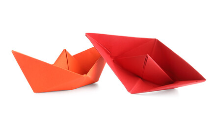 Red origami boats on white background