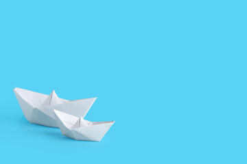 White origami boats on blue background