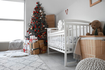 Interior of festive nursery room with decorated Christmas tree and gift boxes