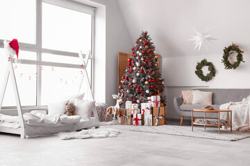 Interior of festive children's bedroom with decorated Christmas tree and gift boxes