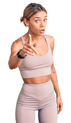 Beautiful caucasian woman wearing sportswear pointing displeased and frustrated to the camera, angry and furious with you