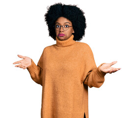 Young african american woman wearing casual clothes clueless and confused expression with arms and...