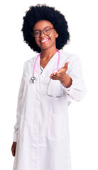 Young african american woman wearing doctor coat and stethoscope smiling cheerful offering palm hand giving assistance and acceptance.