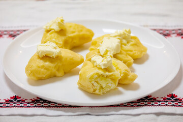 Verenik, pierogi, pierogui, perohê, Ukrainian food closeup on wooden table with wheat flour and rolling pin. 