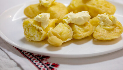 Verenik, pierogi, pierogui, perohê, Ukrainian food closeup on wooden table with wheat flour and rolling pin. 