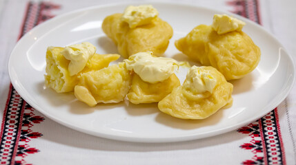 Verenik, pierogi, pierogui, perohê, Ukrainian food closeup on wooden table with wheat flour and rolling pin. 