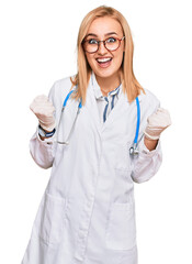 Beautiful caucasian woman wearing doctor uniform and stethoscope celebrating surprised and amazed for success with arms raised and open eyes. winner concept.