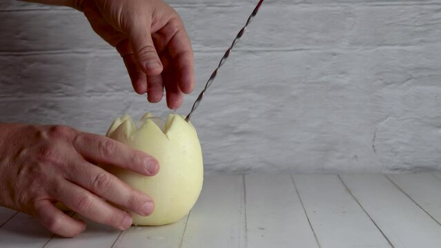 Melon with wine, white melvin, video, preparing, cocktail, adding, ice. On white wooden table, stirrer. Originally from Chile, summer. Typical Chilean food and drink