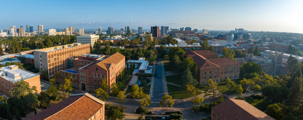 Panoramic early morning view of a serene university campus, blending historic brick buildings with...
