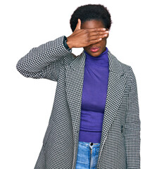 Young african american girl wearing casual clothes covering eyes with hand, looking serious and sad. sightless, hiding and rejection concept