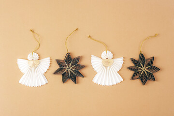 Paper angels and fir tree toys on beige background. Christmas concept. Top view, flat lay