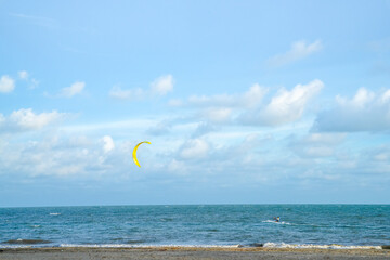 sea water with blue sky. people are playing parachute.