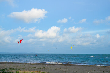 sea water with blue sky. people are playing parachute.