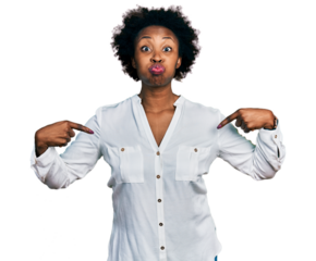 African american woman with afro hair pointing with fingers to herself puffing cheeks with funny face. mouth inflated with air, catching air.