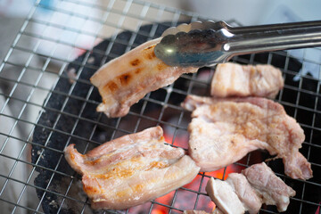 Grilled pork on charcoal grill in Thailand.