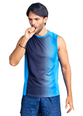 Fototapeta premium Handsome hispanic man wearing sportswear feeling unwell and coughing as symptom for cold or bronchitis. health care concept.