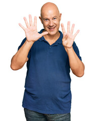 Middle age bald man wearing casual clothes showing and pointing up with fingers number nine while smiling confident and happy.