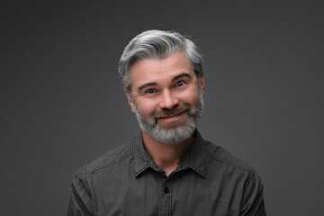 Personality concept. Portrait of bearded man on dark grey background